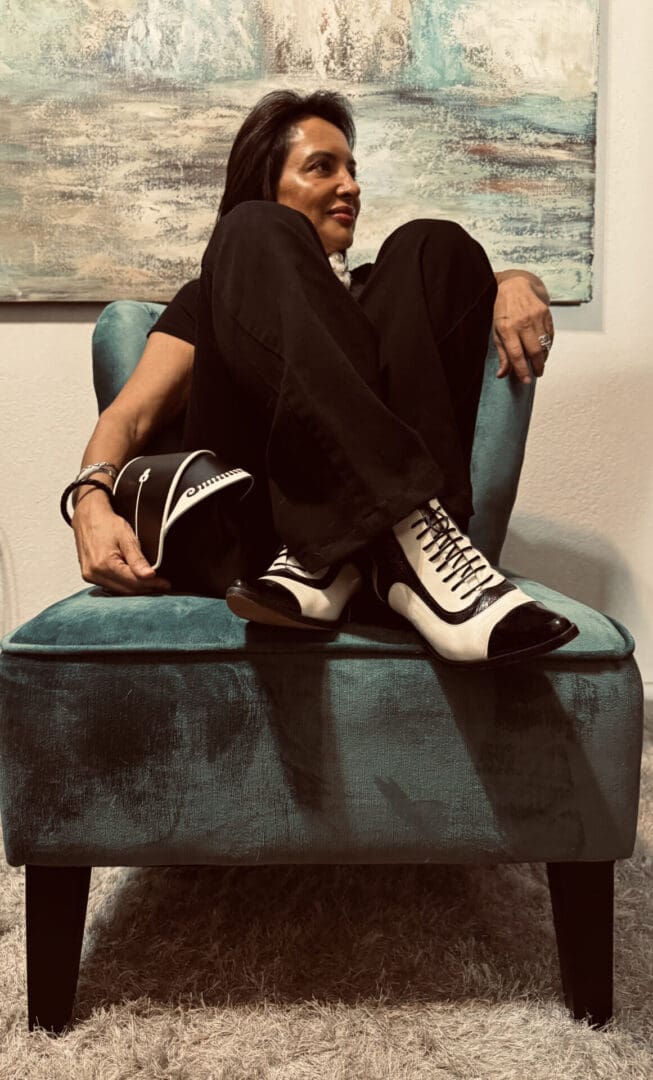 A man sitting on top of a chair wearing white shoes.